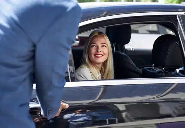 Chauffeur assisting passenger with luggage
